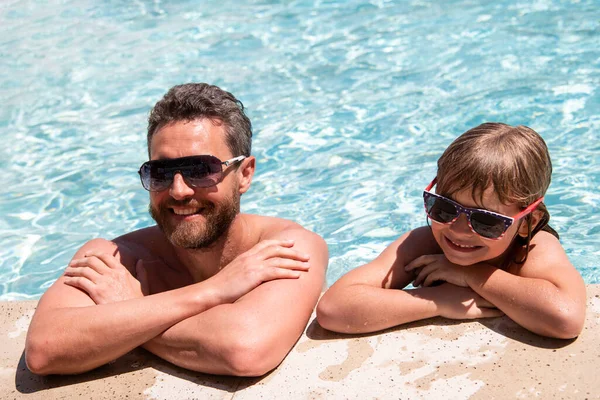 Vader en zoon in het zwembad. Zwembadfeest. Jongen met vader die in het zwembad speelt. Actieve levensstijl. — Stockfoto