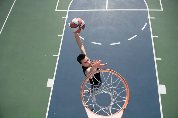 Basketball-Konzept. Mann springt und macht einen Slam Dunk beim Streetball, Basketball. Urbane Authentizität. — Stockfoto