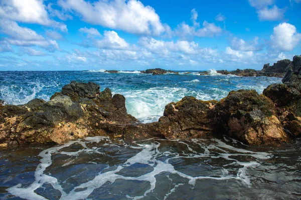 Praia de pedra do mar, ondas do mar. Fundo azul colorido do mar. O conceito de férias de verão e viagens. Água do mar límpida, grandes pedras na praia. — Fotografia de Stock