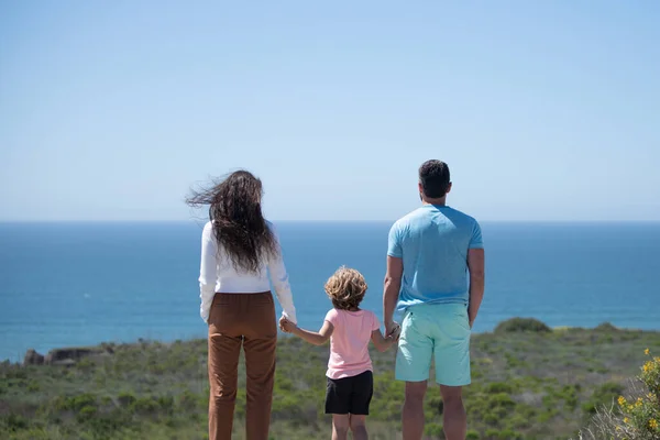 ビーチで幸せな家族。夏休みを楽しんでいる人たち。青い海の上の父、母、子。家族の自由の概念。子供を持つ両親は屋外でリラックスします。週末家族のコンセプト. — ストック写真