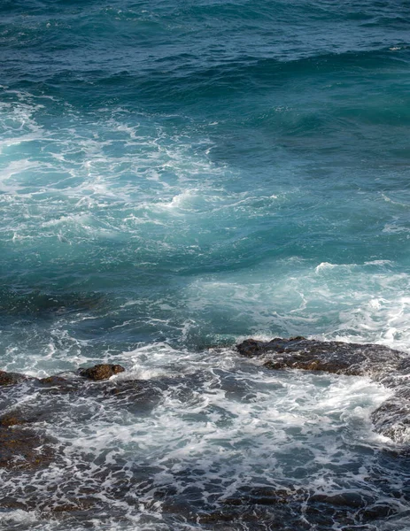 海の背景。嵐の前にスプレーと泡で岩の海岸に衝突する海洋波. — ストック写真
