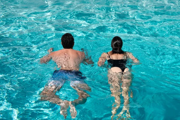 Sommerpaar schwimmt im Pool. Sommerurlaub. Lebensgewinner. Hintern im Bikini. — Stockfoto