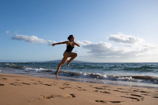 シルエットを動かす女。海上を走る。ビーチコンセプトでスポーツ演習. — ストック写真