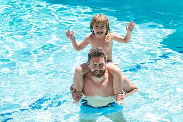 Papá lleva a hombros a un niño divertido en la piscina. Padre e hijo fin de semana. —  Fotos de Stock