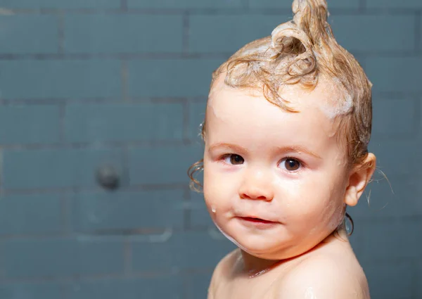 Ένα μικρό παιδί στην μπανιέρα. Το μωράκι λούζει τα μαλλιά της στο μπάνιο.. — Φωτογραφία Αρχείου