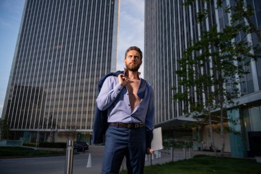 Modern bir açık uzay iş merkezinde yönetici. Dışarıda başarılı bir iş adamı, omuzlarında ceketle..