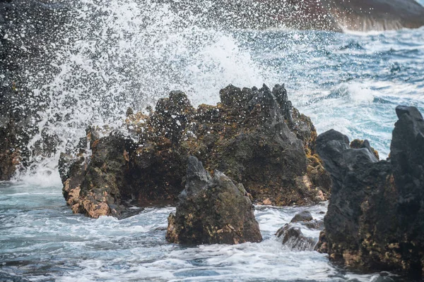 Espalhando ondas na rocha no mar. Onda atingiu a pedra no oceano com um fundo de água. — Fotografia de Stock