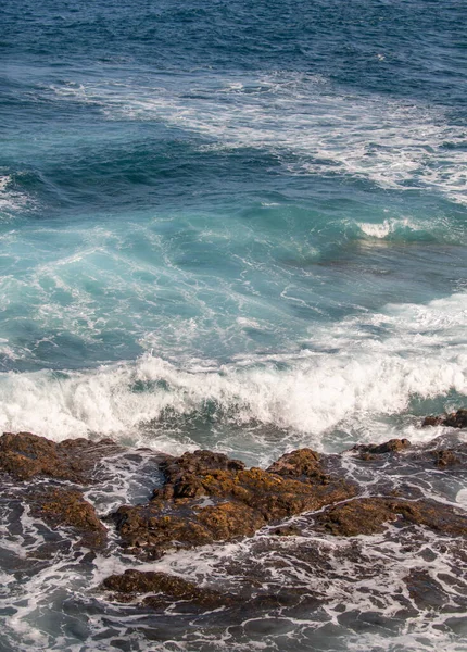 El mar choca con las piedras y la arena de una playa. mar olas látigo línea impacto roca. — Foto de Stock