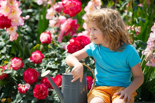 Маленька дитина ходить біля квітки в прекрасний весняний день. Хлопчик на відкритому повітрі в саду з лійкою . — стокове фото