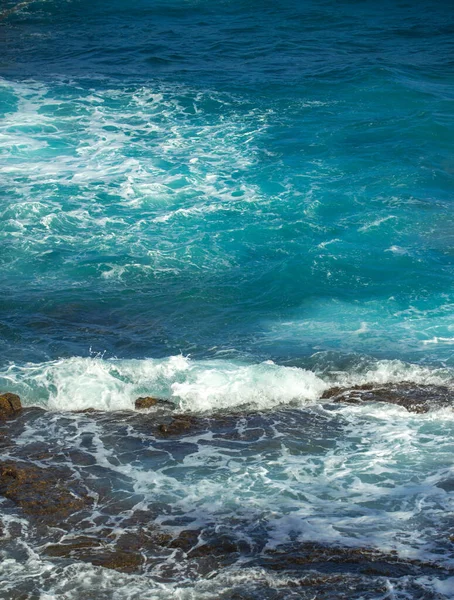 Скелясте узбережжя моря. Прекрасні бірюзові води моря. Океанічні хвилі проти прибережних порід. Вигляд сцени в океані. Чудовий літній морський мис.. — стокове фото