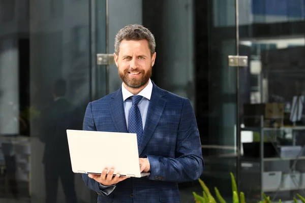 Retrato de hombre de negocios guapo usando el ordenador portátil al aire libre. —  Fotos de Stock