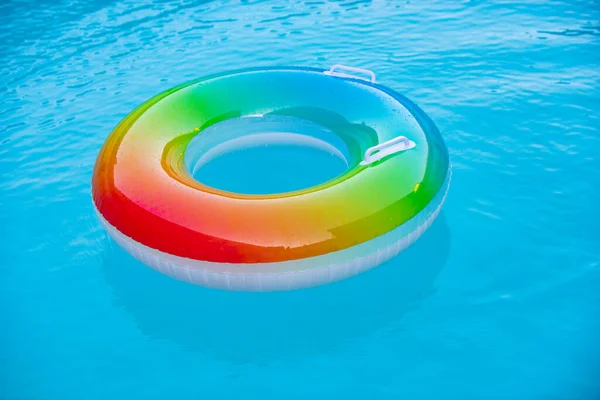 Δαχτυλίδι που επιπλέει σε γαλάζια πισίνα με κύματα που αντανακλούν το καλοκαίρι. Μπλε aqua υφή φόντου. — Φωτογραφία Αρχείου