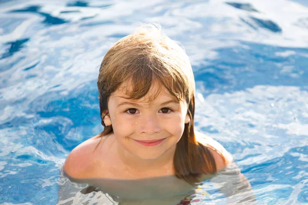 Счастливый мальчик играет и в бассейне или в морской воде. Веселые детишки. — стоковое фото