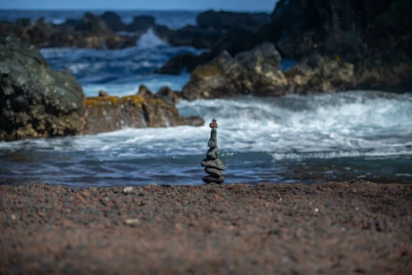 石はビーチの砂の上でバランスをとる。設計のための海の石からの背景. — ストック写真