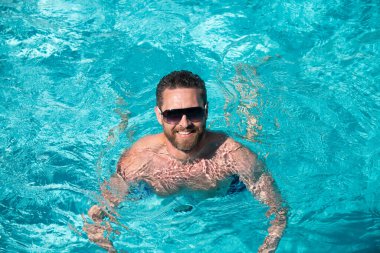 Yaz tatili. Yüzme havuzunda yakışıklı bir adam. Havuz partisi. Yaz tatili. Yaz haftasonundaki adam.
