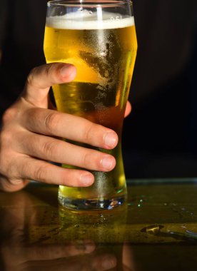 Bira bardakları. Adam el ele tutuşup bir bardak bira içiyor..