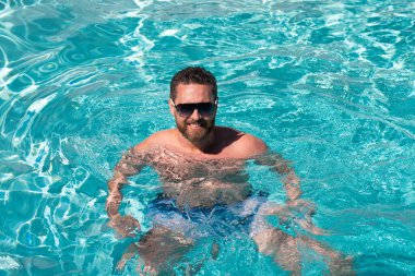 Havuz kaplıcası. Yaz tatilinde bilardoda. Yaz haftasonu. Yüzme havuzunda yakışıklı bir adam.