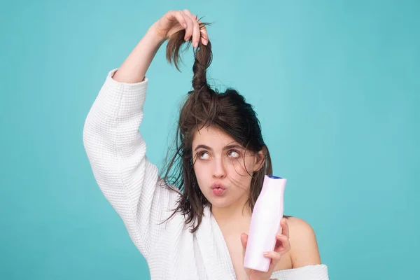 Verrast verbaasde vrouwen haarverzorging. Vrouw met flessenshampoo en conditioner. Meisje met haarconditioner. — Stockfoto