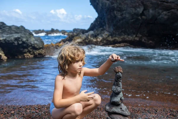 子供と石の塔は海に近い。完璧な瞑想のためにビーチで禅の石。海の小石の塔。落ち着いて。子供たちの落ち着いたテクニック. — ストック写真