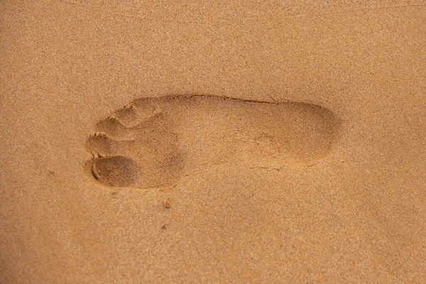 Arrière plan fermer les empreintes de pieds humains sur le sable sur le sable. — Photo