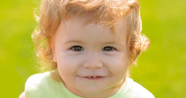 Retrato infantil caucásico de cerca. Cara de bebé. Sonriente bebé, linda sonrisa. Parque al aire libre de verano. —  Fotos de Stock