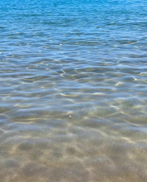 Fondo de textura de agua de mar abstracto o ondulado. Calma textura de la superficie del agua con salpicaduras y olas. Fondo abstracto de la naturaleza. Superficie de agua azul del océano. — Foto de Stock