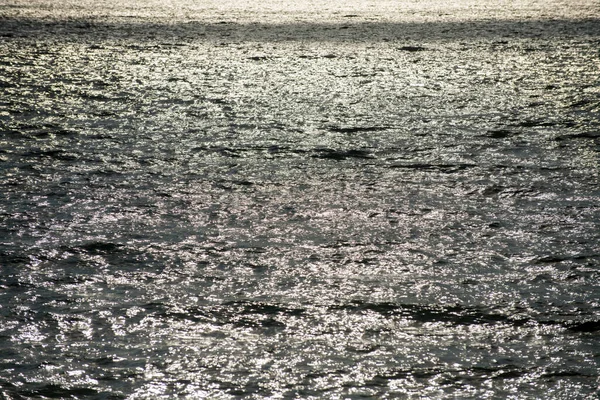 Zeeabstracte of rimpelende water textuur achtergrond. Rustig wateroppervlak textuur met spatten en golven. Abstracte natuur achtergrond. Oppervlakte blauw oceaanwater. — Stockfoto