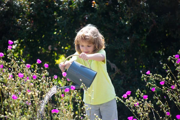 Bonito menino criança regando flores com regador. Crianças jardinagem. — Fotografia de Stock