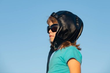 Pilot kasklı ve gözlüklü küçük bir çocuğun portresi. Çocuk kavramı yakın planda. Çocuk portresi. Çocuklar rüya görür.