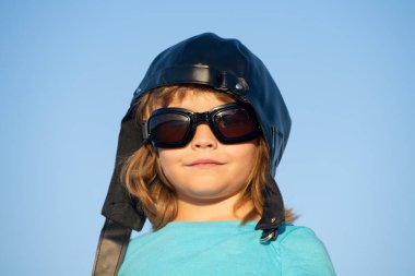 Çocuklar rüya görür. Pilot kasklı, gözlüklü, komik portresi olan beyaz bir çocuk. Çocuk yüzü.