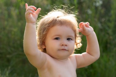 Çocuğun kafasından yakın çekim. Çocuk yüzü, küçük bebek portresi yeşil doğa parkında.