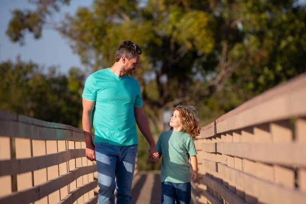 Vader met zoon wandelen op bosrijke brug buiten. — Stockfoto