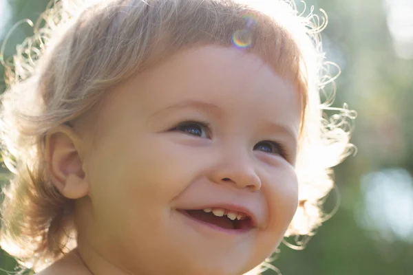 Feche o retrato de um pequeno menino loiro. Crianças engraçadas cortadas rosto ao ar livre no dia ensolarado. Crianças sorrindo, sorriso bonito. — Fotografia de Stock