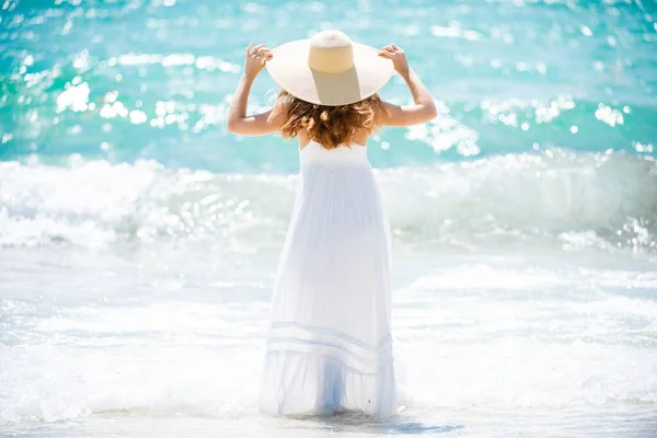 Вид сзади молодой привлекательной девушки с идеальным телом на летнем пляже. Сексуальная женщина в море, чувственная женщина-модель позирует рядом с океаном фон с копировальным пространством. — стоковое фото