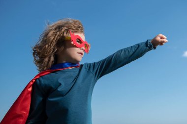 Süper kahraman kostümü giyen bir çocuğun portresi. Süper kahraman çocuk dışarıda eğleniyor. Çocukların güç konsepti.