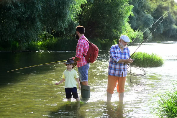 Adoro pescare. Uomo anziano pesca con figlio e nipote. Nonno, padre e figlio pescano a mosca sul fiume. — Foto Stock