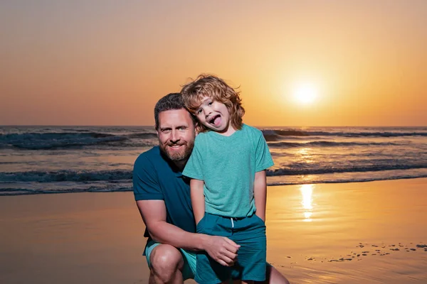 Πατέρας και γιος αγκαλιάζονται στο ηλιοβασίλεμα της παραλίας. Οικογενειακή αγκαλιά στην ανατολή του ηλίου. — Φωτογραφία Αρχείου