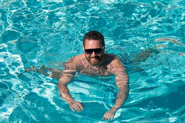 週末だ。スイミングプール。夏休みだ。男はプールで泳ぐ。サマータイムプールリゾート. — ストック写真