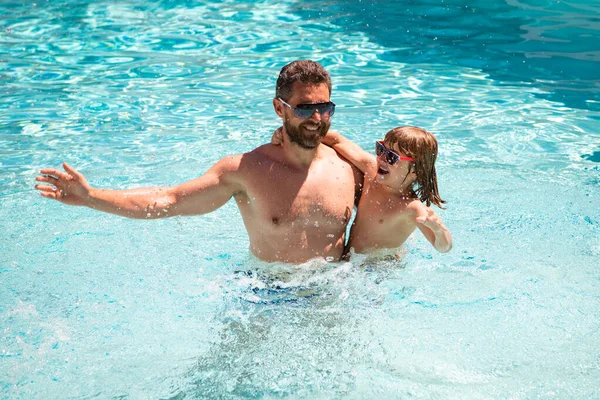 Vader en zoon zwemmen in zwembad, zomer familie weekeng. — Stockfoto