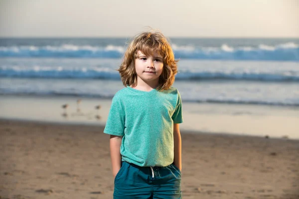 Söt pojke gå havet stranden med handen i fickan. — Stockfoto