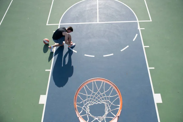 Basketspelare med boll på friluftsplan. — Stockfoto