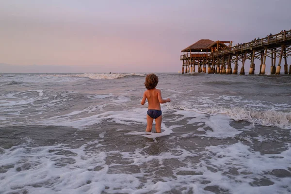 El chico se divierte al aire libre. Vacaciones en el mar, niños divertidos, niños jugando en la playa del océano. Chico jugando con Olas en el mar azul. Concepto de viaje y aventura. — Foto de Stock