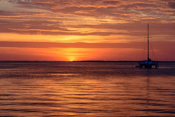 Navegação e iatismo. Barco na água ao pôr-do-sol. Barcos à vela na água do mar oceano. — Fotografia de Stock