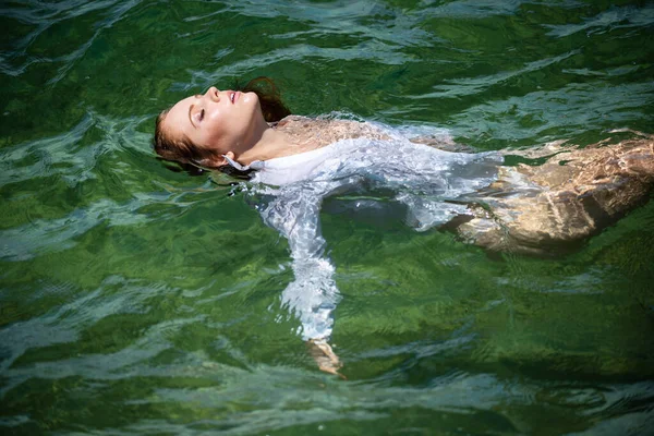 Giovane donna sexy sta nuotando nel mare trasparente e blu. Sensuale donna magra galleggiante sull'acqua dell'acqua dell'oceano. — Foto Stock