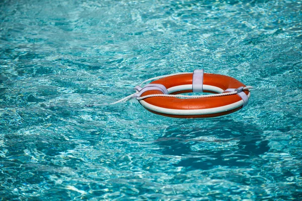 Bóia de vida para a segurança na piscina na água. Equipamento de segurança, bóia de resgate flutuando para resgatar pessoas de afogamento. — Fotografia de Stock