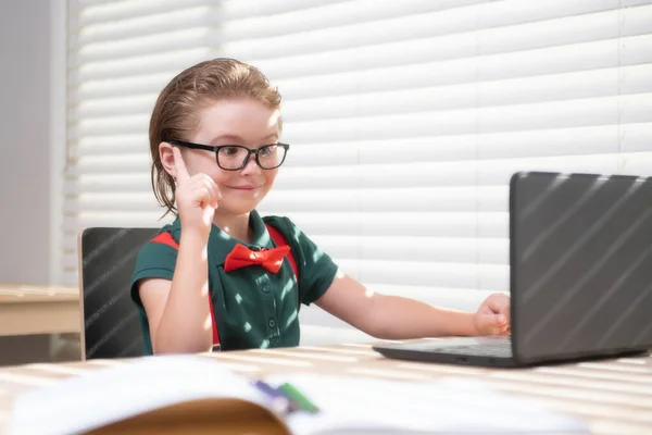 Niño usando un ordenador portátil y estudiar lección en línea. Alumno de la escuela. Lindo niño usando computadora portátil, estudiando en línea. —  Fotos de Stock