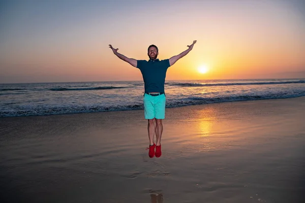 Homme sautant sur la plage, silhouette au coucher du soleil. Vue imprenable sur la plage du coucher du soleil. — Photo