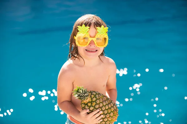 Frutto dell'ananas estivo. Bambino felice divertirsi in piscina nella giornata di sole. Bambini vacanze estive e concetto di vacanza. — Foto Stock