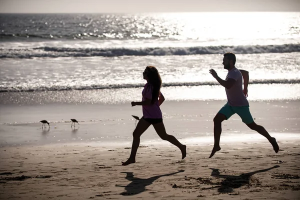 Les coureurs sportifs font du jogging sur la plage. Exercice de fitness en plein air concept. Couple courant sur la plage. — Photo