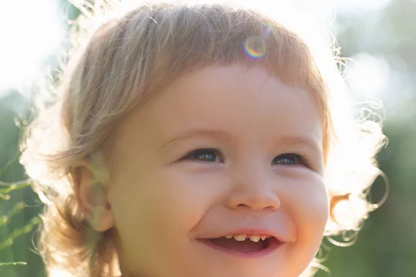 Porträtt av en liten pojke. Begreppet barn beskärs ansikte närbild. Huvudfotografering barn porträtt utomhus. Barn ler, gulligt leende. — Stockfoto